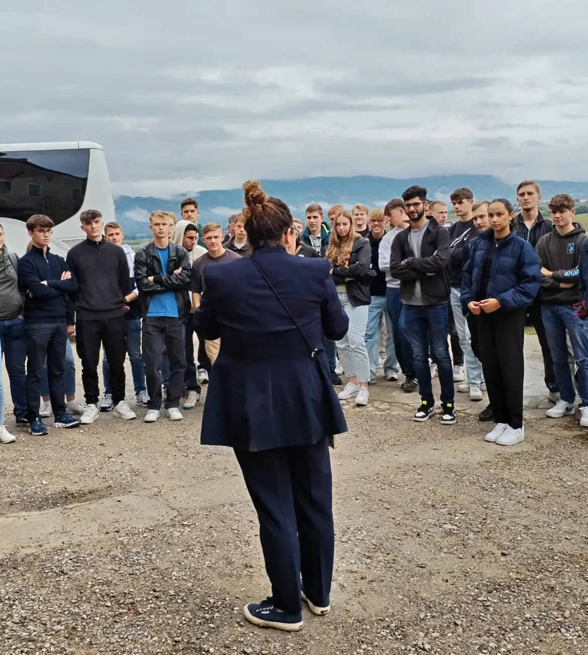 Una guida spiega il frantoio a un gruppo di studenti in visita