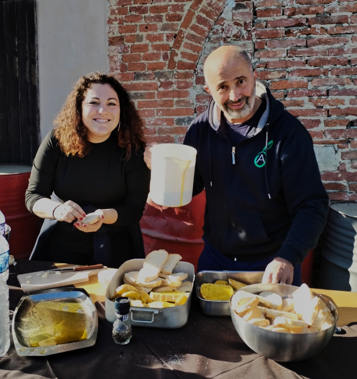 Persone che preparano pane e taglieri per la degustazione dell'olio nuovo